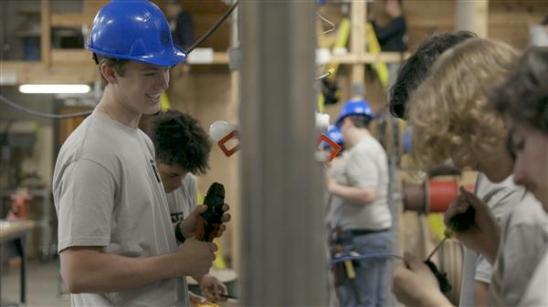 Students smiling and doing electrical work Students smiling and doing electrical work
